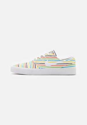 Baskets basses avec semelle blanche et rayures horizontales multicolores en rouge, jaune, vert, bleu et noir, avec un logo Nike swoosh blanc.