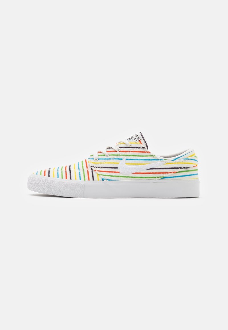 Baskets basses avec semelle blanche et rayures horizontales multicolores en rouge, jaune, vert, bleu et noir, avec un logo Nike swoosh blanc.