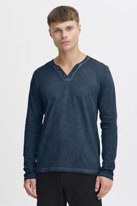 Langärmliges, navyblaues T-Shirt aus weichem Stoff, mit V-Ausschnitt und drei braunen Knöpfen an der Brust. Einfaches und lässiges Design.