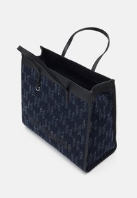 Černá a námořnická taška přes rameno vyrobená z tkané látky s opakujícím se vzorem loga, s pevným tvarem a jediným horním madlem.