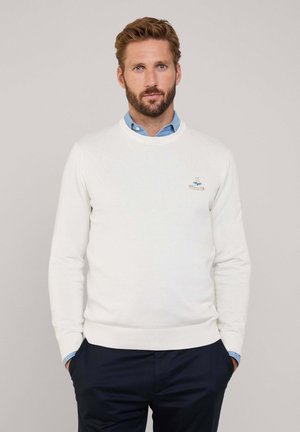 Witte katoenen trui met een ronde halslijn en lange mouwen, voorzien van een klein geborduurd ontwerp op de borst en geribbelde manchetten en zoom.