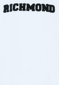 T-shirt bianco con un logo "RICHMOND" nero e testurizzato centrato sul davanti. Il tessuto appare liscio, adatto per un abbigliamento casual.