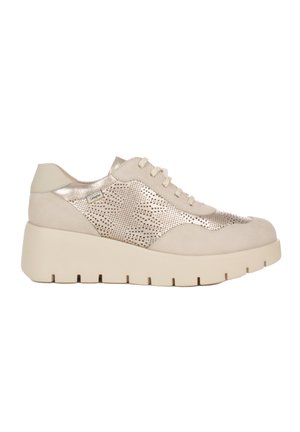 Sneaker beige con platform, pannello laterale metallico traforato, sistema di allacciatura frontale e suola spessa scanalata.