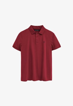 Polo bordeaux a maniche corte con colletto, tre bottoni e un piccolo logo scuro sul petto a sinistra.