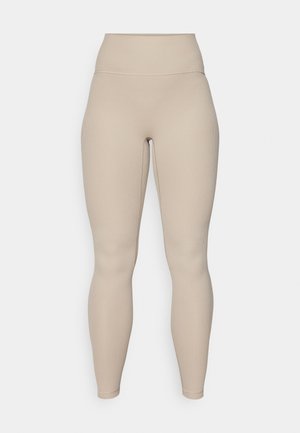 Beige augsto vidukļa legingi ar ribotu tekstūru, kas piedāvā gludu jostasvietu un pieguļošas kājas, paredzēti komfortam un elastīgumam.