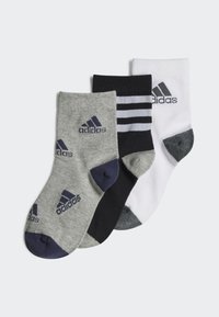 Tres pares de calcetines: grises con talón azul marino, azules marinos con rayas blancas y blancos con talón gris. Todos cuentan con el logo de Adidas.