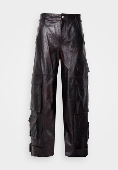 Μαύρο δερματίνη cargo παντελόνι με πολλές τσέπες, ίσια γραμμή και διακριτική γυαλάδα. Διαθέτει κουμπί στη μέση και αντίθετη ραφή.