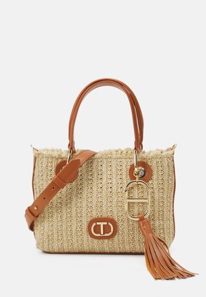 Woven straw handbag with brown leather accents, two handles, detachable shoulder strap, gold hardware, and a tassel detail.