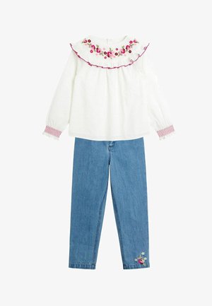Polo alb cu mâneci lungi, cu broderie florală pe guler, asociat cu pantaloni din denim blue cu detalii de broderie florală pe picior.