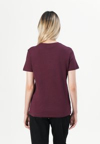 Bordeaux t-shirt med kort ärm gjord av mjuk bomull, med rund halsringning, enkel design och avslappnad passform utan synlig varumärkeslogotyp.