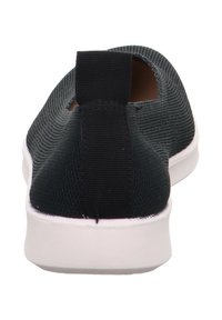 Schwarze Strick-Slipper mit strukturierter Oberseite, elastischer Fersenschlaufe und kontrastierender weißer Gummisohle. Minimalistisches Design und glatte Oberfläche.