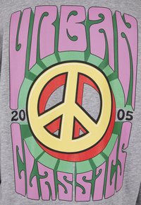 Šedé tričko s velkým multicolor symbolem míru, s tučnými nápisy "URBAN CLASSICS" a "2005" a dekorativními vzory.
