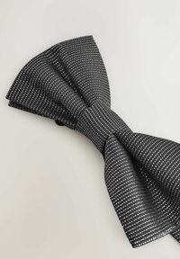Black bow tie with a textured surface, featuring white pinstripes. The tie has a central knot and wide, pointed ends.