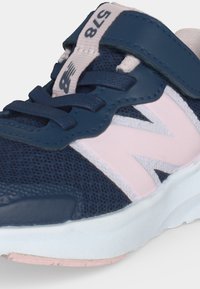 Παπούτσι New Balance σε ναυτικό μπλε και ροζ χρώμα με πλέγμα υφάσματος, κορδόνια, ιμάντα με βέλκρο και λευκή σόλα με τον αριθμό μοντέλου 578 στη γλώσσα.