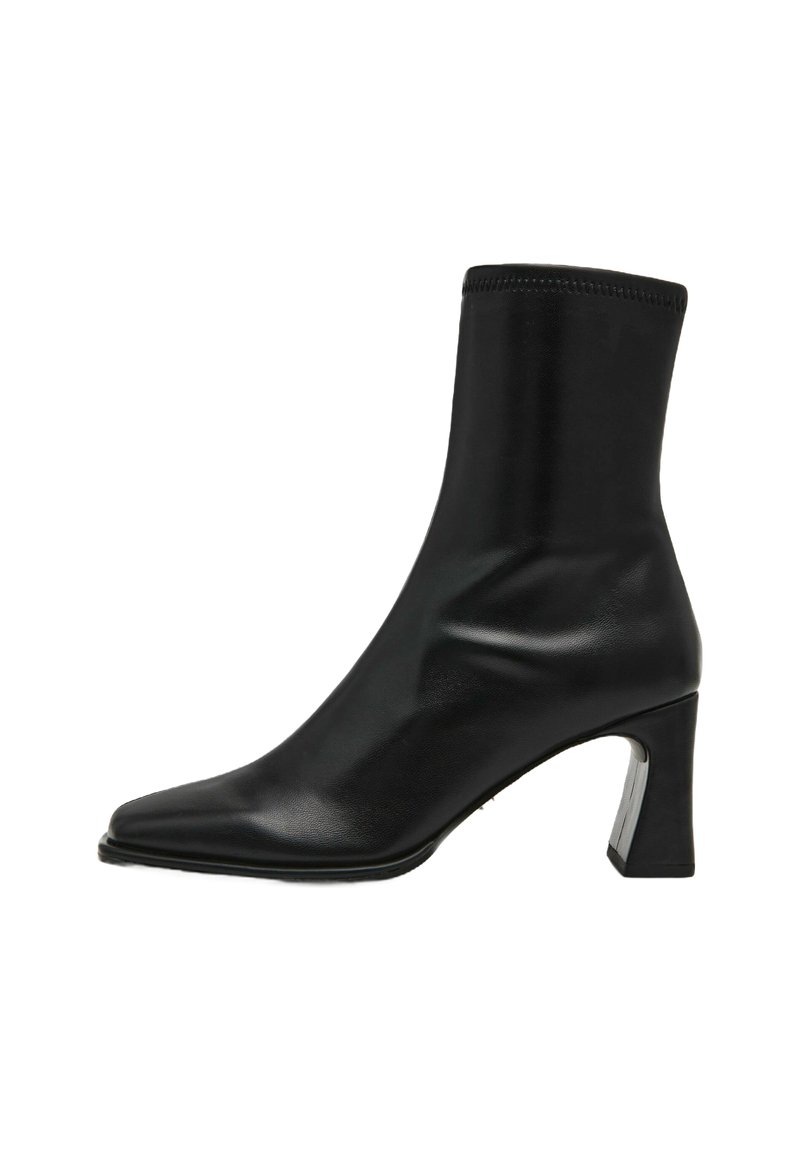 Stivale alla caviglia in pelle nera con punta affusolata, vestibilità aderente e tacco quadrato con un accento metallico. Texture liscia con dettagli minimi.