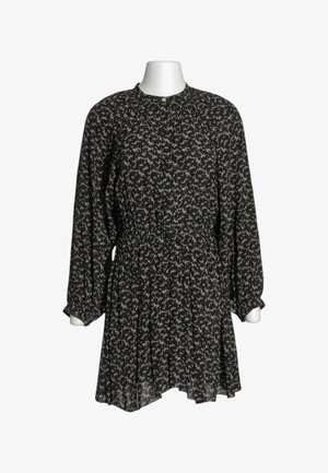 Schwarzes Langarmkleid mit weißem abstraktem Muster, rundem Ausschnitt, geraffter Taille und leicht ausgestelltem Rock auf einer weißen Schaufensterpuppe.
