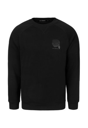 Czarna bluza z okrągłym dekoltem, raglanowymi rękawami i teksturowanym logo na piersi. Wykonana z miękkiego materiału, z prążkowanymi mankietami i dołem.