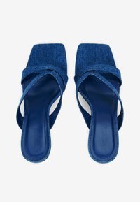 Blaue Jeans-Sandalen mit quadratischer Zehenform und überkreuzten Riemen. Glatte Innensohle mit Logo-Prägung, strukturierte äußere Riemen.