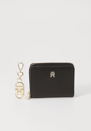 Zwarte leren portefeuille met gouden hardware, ritssluiting en logoaccent. Inclusief een sleutelhanger met een bijpassende gouden clip en ontwerpdetail.