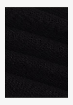 Close-up van zwart gebreid stof met fijne, gelijkmatige stiksels en een zachte textuur met zachte vouwen.