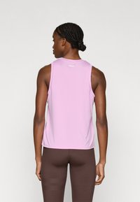 Ανοιχτό ροζ αμάνικο τοπ με στρογγυλή λαιμόκοψη και ελαφρώς φαρδιά γραμμή, με ένα μικρό λογότυπο στο πίσω μέρος.