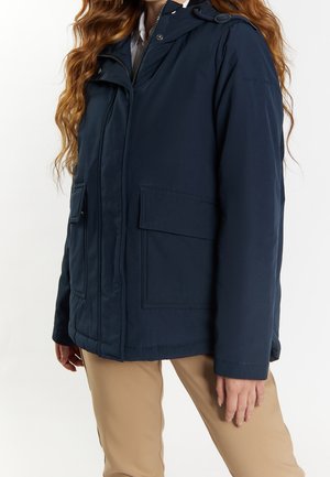 Marineblauwe geïsoleerde jas met een frontale ritssluiting, grote opgestikte zakken en een afneembare capuchon. Gladde textuur met zichtbare stiksels.
