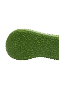 Suela de zapato de goma verde con un patrón de estrellas y estrellas pequeñas. Superficie texturizada con puntos elevados para mayor agarre. Presenta elementos de diseño divertidos.