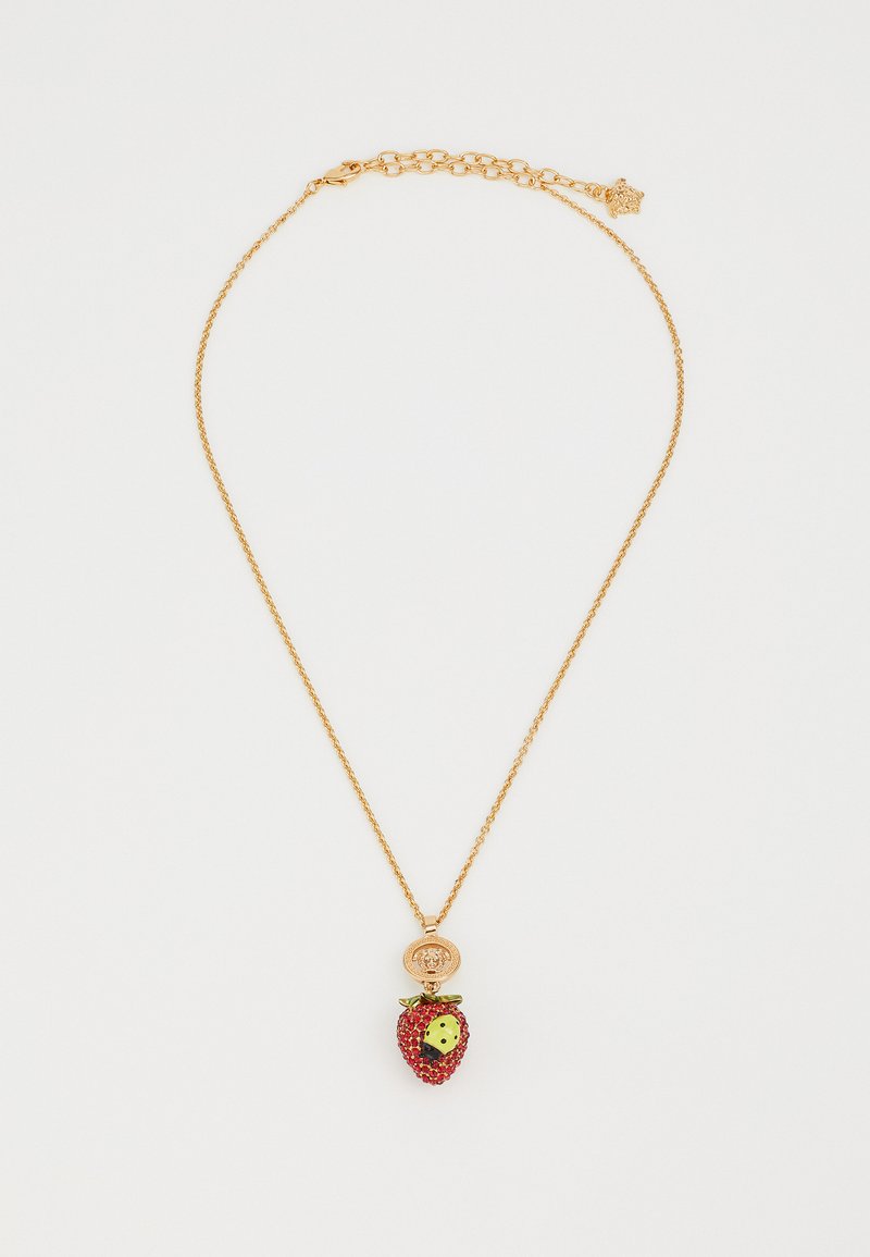 Gold-tone necklace featuring a strawberry pendant adorned with red and green accents, including small black dots and a decorative charm.