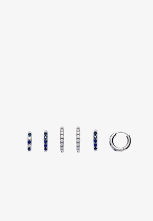 Six small silver hoop earrings with alternating blue and clear gemstones, shown from front and side views on a white background.