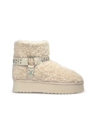 Stivaletti alla caviglia in finta pelliccia beige con suola piatta e texturizzata e una cinghia in pelle regolabile con borchie metalliche e una fibbia circolare.