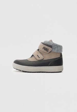 Bottes pour enfants avec une tige beige et un col en feutre gris, deux bandes Velcro, accents noirs et semelle en caoutchouc texturée.