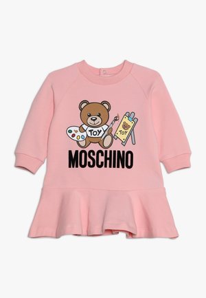 Robe en coton rose avec un motif d'ours tenant des fournitures artistiques et le texte « MOSCHINO ». Ourlet évasé, encolure ronde et manches longues.