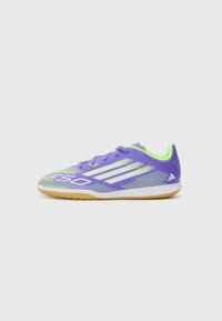 Zapatilla deportiva morada con detalles en blanco y forro verde lima. Presenta una parte superior de malla transpirable y suela de goma para tracción.
