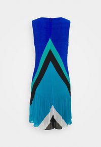 Robe bleue et bleu sarcelle avec un haut ajusté et une jupe évasée, présentant des motifs chevrons audacieux en noir et blanc. Fabriquée en tissu léger et texturé.