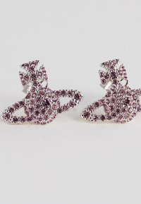 Øredobber i sølvfarge formet som stiliserte planeter med ringer, besatt med små rosa og lilla edelstener.