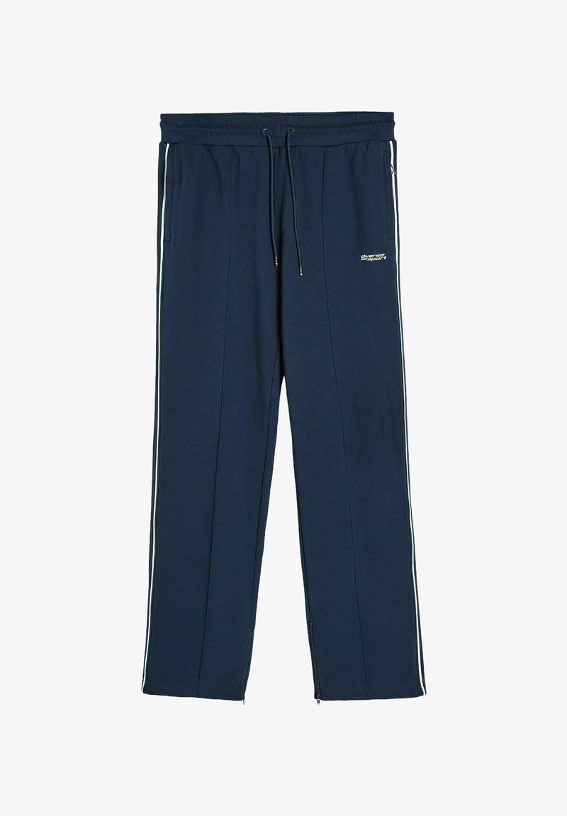 Granatowe spodnie dresowe wykonane z lekkiego materiału, z bocznymi paskami, elastycznym paskiem w talii ze sznurkiem oraz zamkami błyskawicznymi przy kostkach.