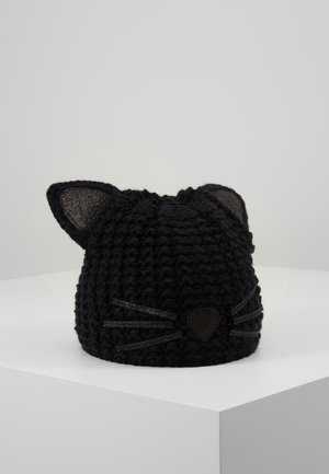 Bonnet noir tricoté avec des oreilles de chat, des détails scintillants à l'intérieur des oreilles, ainsi que des décorations de moustaches et de nez sur un socle blanc.