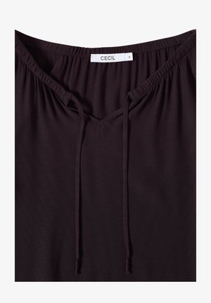 Top viola scuro con scollatura rotonda, dotato di un design con apertura a chiave e cordini regolabili. Tessuto morbido con una texture liscia. Etichetta del marchio visibile.