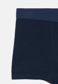 Μπλε ναυτικό βαμβακερά μπόξερ με μονόχρωμη μέση, λεία υφή και ραφές κατά μήκος των άκρων για ασφαλή εφαρμογή.