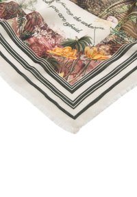Coin de tissu à motif floral avec des fleurs jaunes, des feuilles vertes et une bordure rayée noire sur fond crème.