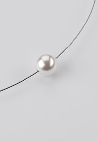 Perlenanhänger an einem dünnen, metallischen Draht. Die kugelförmige Perle ist glatt und glänzend, in einer hellen Cremefarbe mit einem subtilen Schimmer.