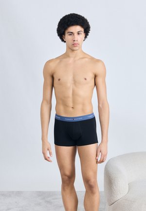 Μαύρα ανδρικά μποξέρ με μπλε ζώνη μέσης που φέρει το λογότυπο "TOMMY HILFIGER". Το ύφασμα είναι απαλό, εφαρμοστό και ελαστικό.