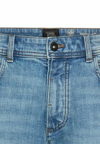 Blue denim jeans with a regular fit, featuring a button closure, five pockets, and subtle fading across the fabric. Brand label visible.