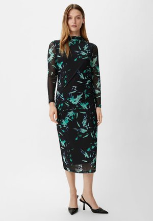 Robe noire à manches longues avec une superposition transparente, dotée d'un motif floral abstrait vert et bleu. Silhouette crayon et encolure ras du cou.