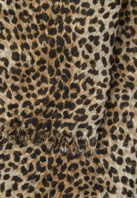 Ανοιχτό καφέ ύφασμα με μαύρα και σκούρα καφέ ακανόνιστα σημάδια λεοπάρ και ξεφτισμένες άκρες.