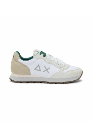 Sneaker bianca e beige con lacci verdi e fodera interna, logo geometrico grigio sul lato e suola in gomma marrone, vista dal lato interno.