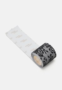 Ruban en dentelle noire avec motif floral, présentant une finition brillante. Un rouleau montre une section déballée, révélant un fond blanc avec un texte subtil.