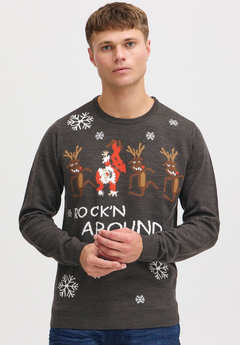 Grå strikket sweater med et festligt design med rensdyr og snefnug, samt teksten "ROCK'N AROUND" i hvid.