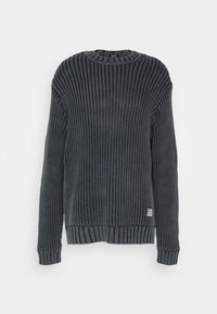 Pull en maille de couleur bleu foncé avec un motif côtelé texturé. Présente un col rond ainsi que des poignets et un ourlet côtelés. Petite étiquette en bas.