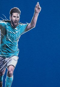 T-shirt en coton bleu avec un motif représentant un joueur en maillot turquoise, vêtu de manches courtes et de shorts blancs, célébrant les bras levés.